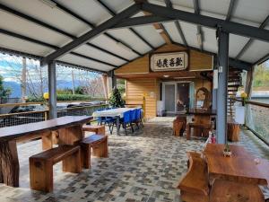 un restaurante con bancos de madera y una mesa en Happy Farm Homestay, en Fuxing