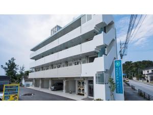 a white building with a sign in front of it at Hotel Thomas Nago - Vacation STAY 40485v in Nago