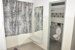 a bathroom with a toilet and a shower curtain at Hotel Sree Vasudev in Vijayawāda
