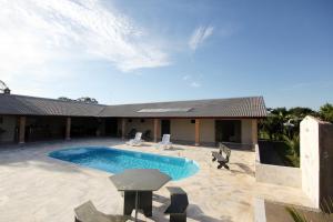 a swimming pool in front of a house at Recanto Vale do Sol in Olímpia