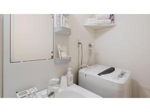 Baño blanco con lavadora junto a un lavabo en Hotel Thomas Nago - Vacation STAY 40430v, en Nago
