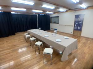 une salle de conférence avec une grande table et des chaises dans l'établissement 多目的スタジオ月兎園 BBQや花火できます #Ok1, à Yoshioka