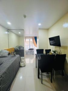 een slaapkamer met een bureau, een bed en een spiegel bij Megatower 1 Residences, Condominium Transient in Baguio