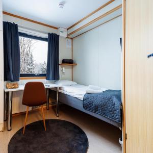 1 dormitorio con cama, escritorio y ventana en Western Farm Village, en Boden