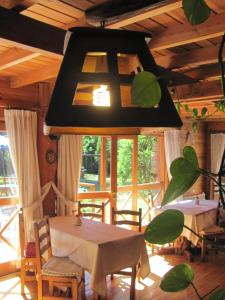 Un comedor con una mesa y sillas y una lámpara de araña. en Hosteria Pichi Rincon, en Villa La Angostura