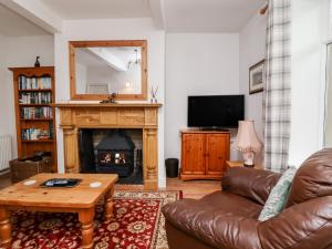 sala de estar con sofá y chimenea en Upper Highlees Farm, en Luddenden Foot