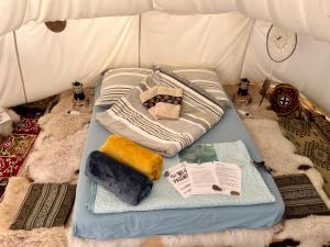 Bett in einem Zelt mit Kissen und Handtüchern in der Unterkunft Romantic Wildlife Tipi Teepee Tomnatic Bihor Romania Apuseni in Tomnatic