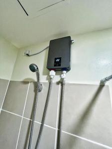La salle de bains est pourvue d'une douche et d'un téléphone mural. dans l'établissement QFandZ Baguio Homestay at Brenthill Condominium, à Baguio
