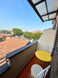 a balcony with a yellow table and chairs on a roof at Design Home at garda Lake in Desenzano del Garda