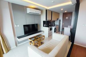 a living room with a couch and a flat screen tv at Seaview Condo In 5 Star Resort MG1 in Phuket Town