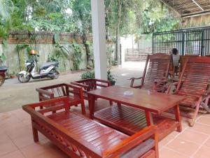 a patio with a table and chairs and a scooter at SRL Villa in Phumi Ta Phul