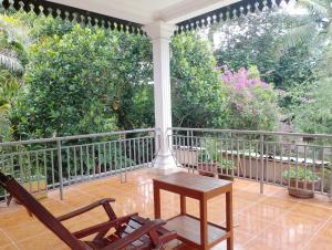 un balcón con 2 sillas y una mesa. en SRL Villa en Phumi Ta Phul