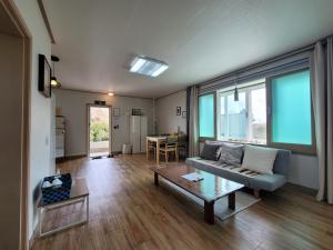 a living room with a couch and a table at Jeju Mermuri in Seogwipo