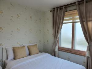 Postel nebo postele na pokoji v ubytování Jeju Mermuri