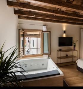 a large bath tub in a room with a window at B&B Casin dei Nobili in Venice