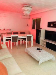 a living room with pink walls and a table and chairs at Tunis Comfort Family Home in Burj at Turkī