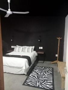 a bedroom with a large bed and a black wall at Prosper Stud Guest House in Robertson