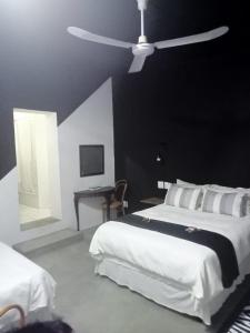 a bedroom with two beds and a ceiling fan at Prosper Stud Guest House in Robertson