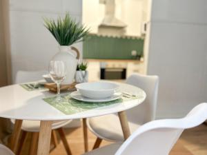 - une table blanche avec un bol et un verre dans l'établissement Apartamento Plaza, à Castilleja de la Cuesta