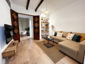 sala de estar con sofá y TV en Apartamento Plaza, en Castilleja de la Cuesta