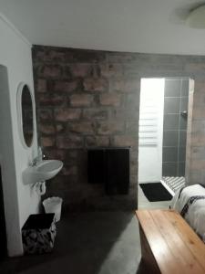 a bathroom with a sink and a stone wall at Prosper Stud Guest House in Robertson