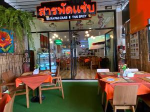 un ristorante con tavoli e sedie di fronte a una finestra di Super Som Rawai a Rawai Beach