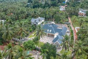 an aerial view of a house with palm trees at StayVista at The Stone Villa with Basketball Court in Kozhikode