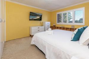 ein Schlafzimmer mit einem weißen Bett und einem Fenster in der Unterkunft Oceancrest 11 in Forster