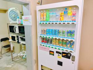 einem Kühlschrank mit vielen Flaschen Soda in der Unterkunft エスタールゴヤ in Tomari