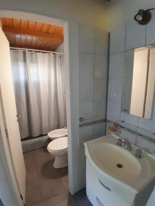 biała łazienka z toaletą i umywalką w obiekcie Casa con jardín - Circuito Chico, Bariloche w mieście Bariloche