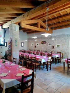 a dining room with pink tables and wooden chairs at Agriturismo Da Andreina in Borso del Grappa