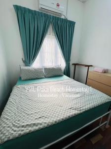 a bedroom with a bed with green curtains and a window at Traveler homestay paka 3-6pax in front Surau and near Paka Beach - Y2L Homestay 1 in Paka