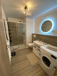 uma casa de banho com uma máquina de lavar roupa e um lavatório em Moderný apartmán s výhľadom na Vysoké Tatry em Poprad