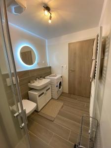 uma casa de banho com um WC, um lavatório e um espelho. em Moderný apartmán s výhľadom na Vysoké Tatry em Poprad