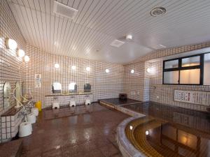 a large bathroom with sinks and toilets in it at Tabist Hotel Yamashiro Onsen in Kofu
