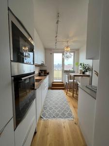 a kitchen with white cabinets and a dining room at Sky view apartment, Stockholm in Solna