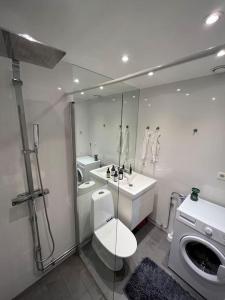 a bathroom with a toilet and a sink and a mirror at Sky view apartment, Stockholm in Solna