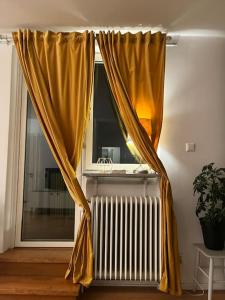 a window with yellow curtains next to a radiator at Sky view apartment, Stockholm in Solna