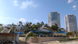 ośrodek wypoczynkowy z niebieskimi parasolami i budynkami w obiekcie Ocean View w mieście Playas