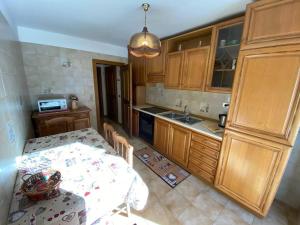 a kitchen with a table and a kitchen with wooden cabinets at Ciamorc Relax & Sport Appartament for max 2 Adults 1 child 1 infant in Canazei +29 photos