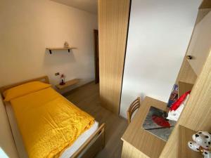 a small room with a bed and a table at Ciamorc Relax & Sport Appartament for max 2 Adults 1 child 1 infant in Canazei