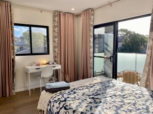 a bedroom with a bed and a desk and a window at Penshurst Guest House in Sydney