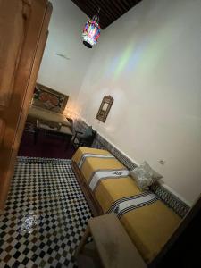 een kamer met 2 bedden en een dambord vloer bij Riad Ranya in Fès