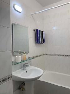 a white bathroom with a sink and a mirror at Paradise Gardens 3 - superb 1 bed apartment in Paphos