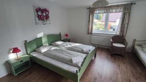 a bedroom with a green bed and a window at Apartmán Šumiac 2 in Šumiac