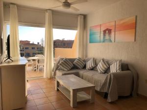 a living room with a couch and a table at Limnaria Gardens - 1 bedroom, sunny apartment with stunning pool views in Paphos City