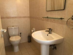 a bathroom with a sink and a toilet at Limnaria Gardens - 1 bedroom, sunny apartment with stunning pool views in Paphos City +13 photos