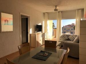 a living room with a glass table and a couch at Limnaria Gardens - 1 bedroom, sunny apartment with stunning pool views in Paphos City