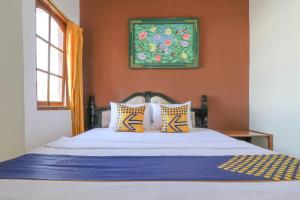 a bedroom with a bed with orange walls at SUPER OYO 1927 Hotel Candra Adigraha in Denpasar