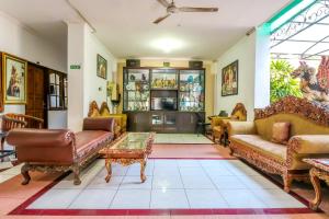 een woonkamer met banken en stoelen en een tafel bij SUPER OYO 1927 Hotel Candra Adigraha in Denpasar